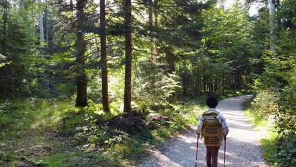 Sticker - Slow motion video of a black woman with backpack enjoying while hiking alone through the forest.