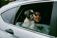 Female And Shih Tzu Dog Looking Out Car Window