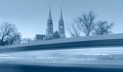 Wall Mural - The Votive Church (Votivkirche) located on the Ringstrasse, Tram moving on a street in the foreground - Vienna, Austria