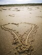 Vertical close-up shot of a heart shape on a sandy beach