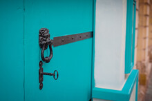 Vintage Iron Or Metal Key In A Lock With Door Knob. Above A Metallic Door Knocker Instead Of A Bell.