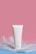 White tube of cream or body lotion on pink background. Natural cosmetic still life product photo 