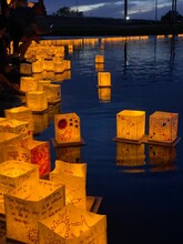 Vertical Of Paper Lanterns Floating On A River During The Water Lantern Festival