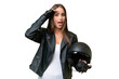Young pretty caucasian woman with a motorcycle helmet over isolated background doing surprise gesture while looking to the side