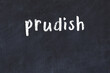 College chalk desk with the word prudish written on in