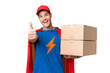 © luismolinero - Super Hero delivery man over isolated background with thumbs up because something good has happened