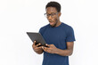 © Mangostar - Shocked man looking at tablet. Young African American male model seeing unexpected information on tablet. Portrait, studio shot, technology concept