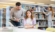 © JackF - Male and female university students working on laptop computer in library, reading books and making notes, preparing to exam