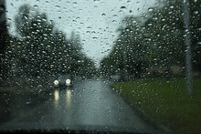 Blurred View Of Road Through Wet Car Window. Rainy Weather