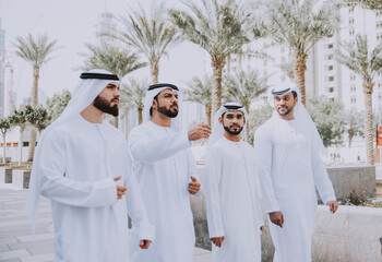 Wall Mural - Group of businessmen talking on the street in Dubai