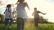 © maxximmm - kids run in the park. a large group of a team of children running back view sunlight in the summer on the grass in the park camera movement. people in the park happy family lifestyle kid dream concept