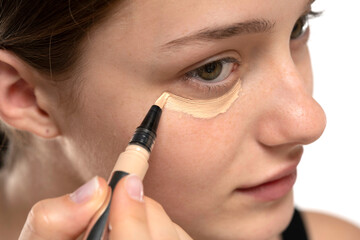 Wall Mural - Woman  applying concealer on flawless fresh skin, doing make up. Girl  put corrector under eye area.