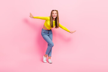 Poster - Full length photo of excited dreamy school girl dressed yellow crop top dancing closed eyes isolated pink color background