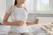 Woman with orthopedic corset sitting in bedroom, closeup