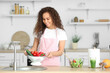 © Pixel-Shot - Young African-American woman with fresh vegetables in kitchen