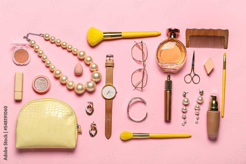 Yellow bag with cosmetics and accessories on pink background