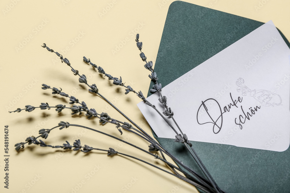 Card with text DANKE SCHON, envelope and lavender flowers on beige background