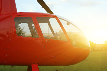 Wall Mural - Modern red helicopter on green grass outdoors