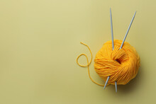 Soft Woolen Yarn And Knitting Needles On Yellow Background, Top View. Space For Text
