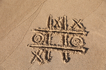 Canvas Print - Tic tac toe game drawn on sandy beach