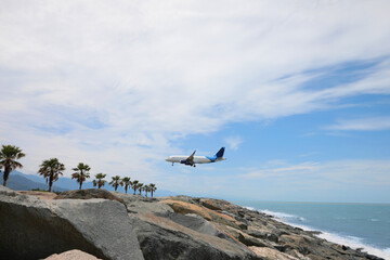 Wall Mural - Modern white airplane landing on rocky seacoast