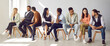 Web narrow banner of multiracial young people sit on chairs in row talk chat in groups. Diverse multiethnic employees or colleagues engaged in teambuilding activity. Teamwork, collaboration concept.