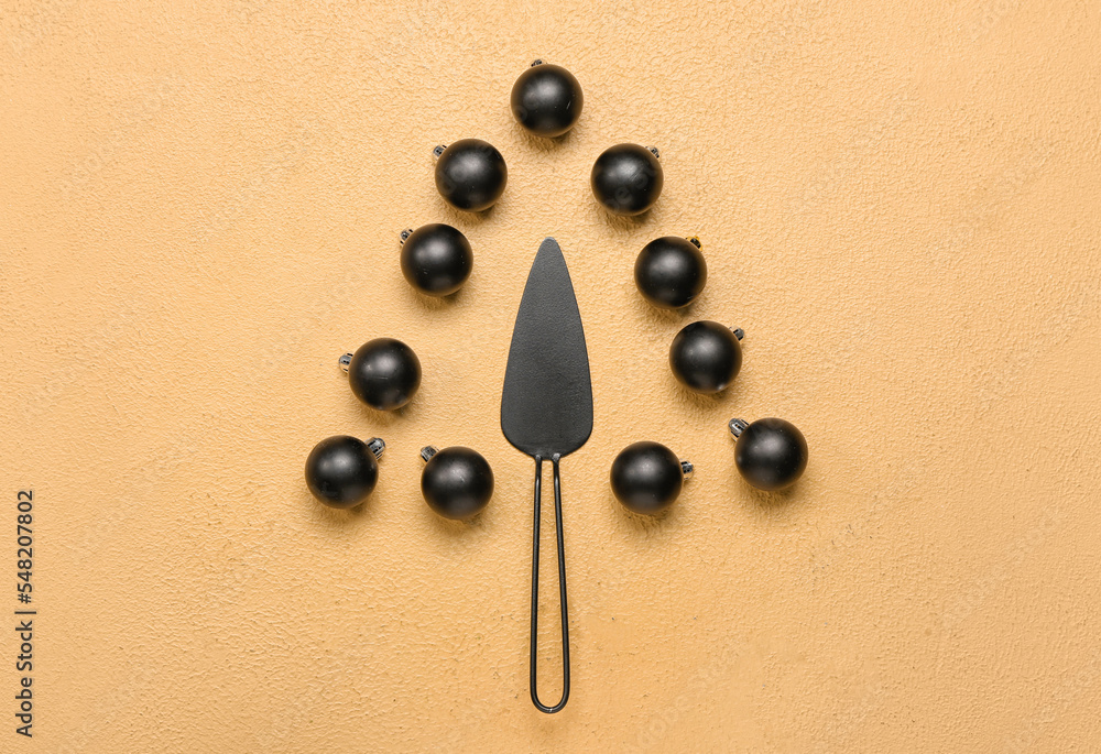 Christmas tree made of cake spatula and balls on beige background