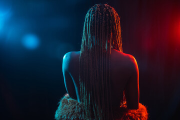 Wall Mural - Woman of black ethnicity with braids with blue and red led lights, portrait with the model on her back