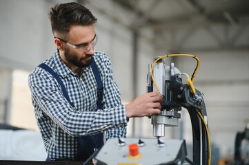 Wall Mural - Worker in uniform working on machine in PVC shop indoor