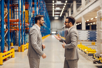 Wall Mural - Business partners talk and negotiate while standing in storage.