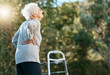 Senior woman, back pain and walking frame for rehabilitation at park for exercise for arthritis, fibromyalgia or osteoporosis problem. Old woman in nature for air, hope and freedom in retirement
