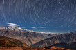 Panoramic night star trails view of Himalaya Mountain Range viewed from Lantang region of Nepal covered with snow and clouds and hills starry blue night abstract background. Starry night nature