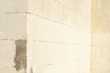 Wall Mural - Corner of a stone wall made of large blocks painted with beige paint