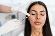 © Dusko - Attractive woman is getting a rejuvenating facial injections at beauty clinic. The expert beautician is filling female wrinkles with botulinum toxin injections or hyaluronic acid fillers.