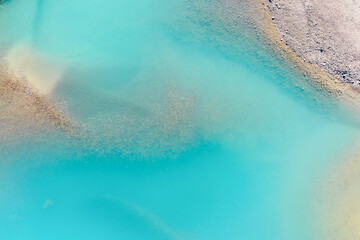 Wall Mural - clear azure water in a mountain lake. the shore with stones. view of the water from a drone. landsca