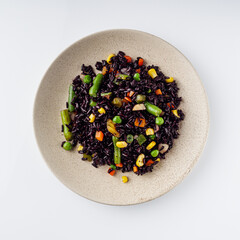 Wall Mural - delicious black rice with vegetables on a white background