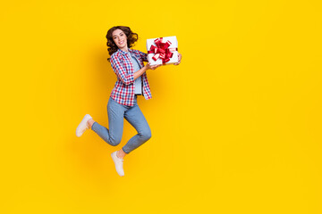 Sticker - Full size photo of nice cute glad woman curly hairstyle dressed checkered shirt hold present flying isolated on yellow color background