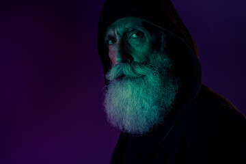 Wall Mural - Photo of suspicious serious retired man dressed black pullover hood empty space looking you isolated dark green purple color background