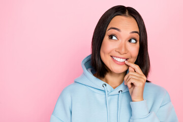 Poster - Photo of adorable pretty lovely lady wear trendy sweatshirt interested look empty space bite fingernail isolated on pink color background