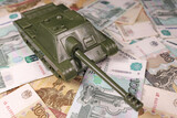 Fototapeta Młodzieżowe - toy tank on russian banknotes roubles, war conflict russia ukraine, sanctions, crisis concept