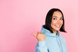 © deagreez - Photo of cute dreamy girl dressed blue sweatshirt looking pointing thumb back empty space isolated pink color background