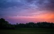 Scenic shot of colorful clouds in the sky during sunset above a grass field