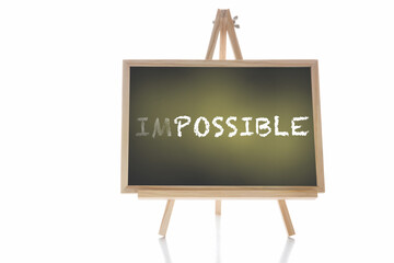 impossible written on chalkboard isolated on white background. Business challenge concept and recovery idea