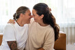 © Brett Edwards/Adobe Stock - Adult lesbian couple intimate on couch at home