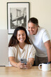 © Brett Edwards/Adobe Stock - Adult lesbian couple use phone in home office