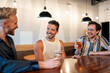 © Brett Edwards/Adobe Stock - LGBTQ Friends sit at a bar with beer and champagne
