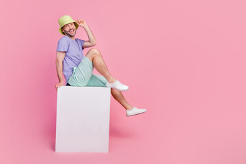 Canvas Print - Full size photo of handsome young guy sit blank banner cube shopping promo dressed trendy blue garment isolated on pink color background