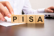 man made word pisa with wood blocks on the background of the office table. selective focus. business concept.