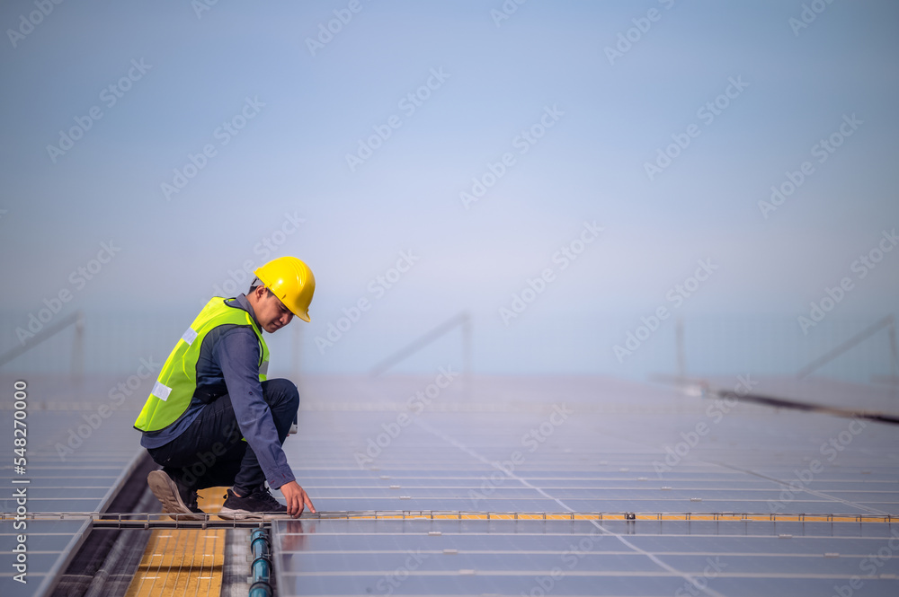 Asian Engineer checking solar power cell energy on rooftop of factory ...