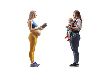 Canvas Print - Full length profile shot of a pregnant woman in sportswear talking to a woman with a baby